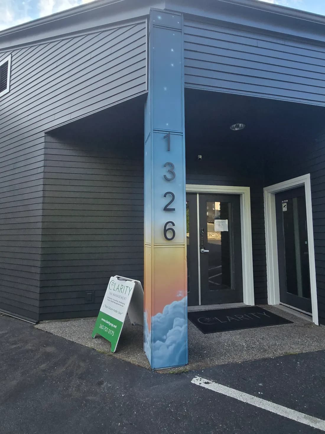 Front door of the Clarity Tax and CPAs Bellingham office with the sandwich board and branded entry mat